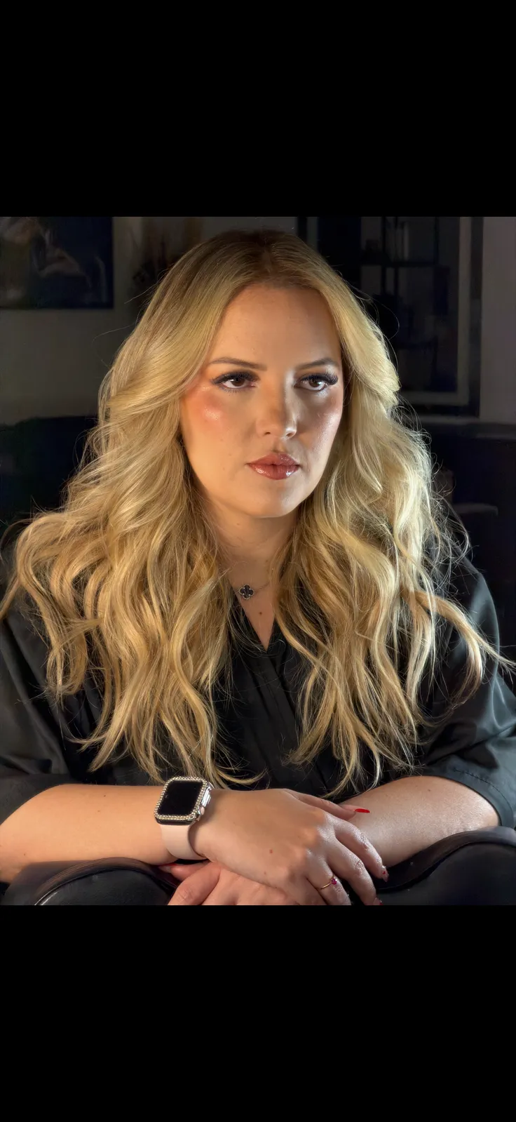 Retrato de Alessandra Alves sentada, em fundo escuro