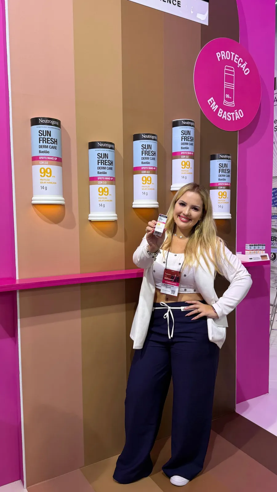 Alessandra em estande com produtos expostos na parede